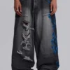 Vaqueros negros Colossus Jeans XL con rotos y diseño «Spike Airbrush»
